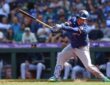 Texas Rangers designated hitter Joc Pederson swings as the ball bounces near his shin guard and dirt sprays at his feet.