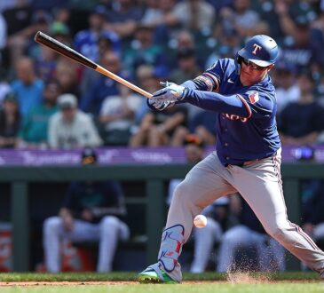 Texas Rangers designated hitter Joc Pederson swings as the ball bounces near his shin guard and dirt sprays at his feet.
