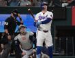 Texas Rangers first baseman Joc Pederson watches his home run as Tampa Bay Rays catcher Liam Hicks and the umpire look up.