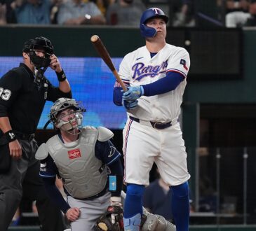 Texas Rangers first baseman Joc Pederson watches his home run as Tampa Bay Rays catcher Liam Hicks and the umpire look up.