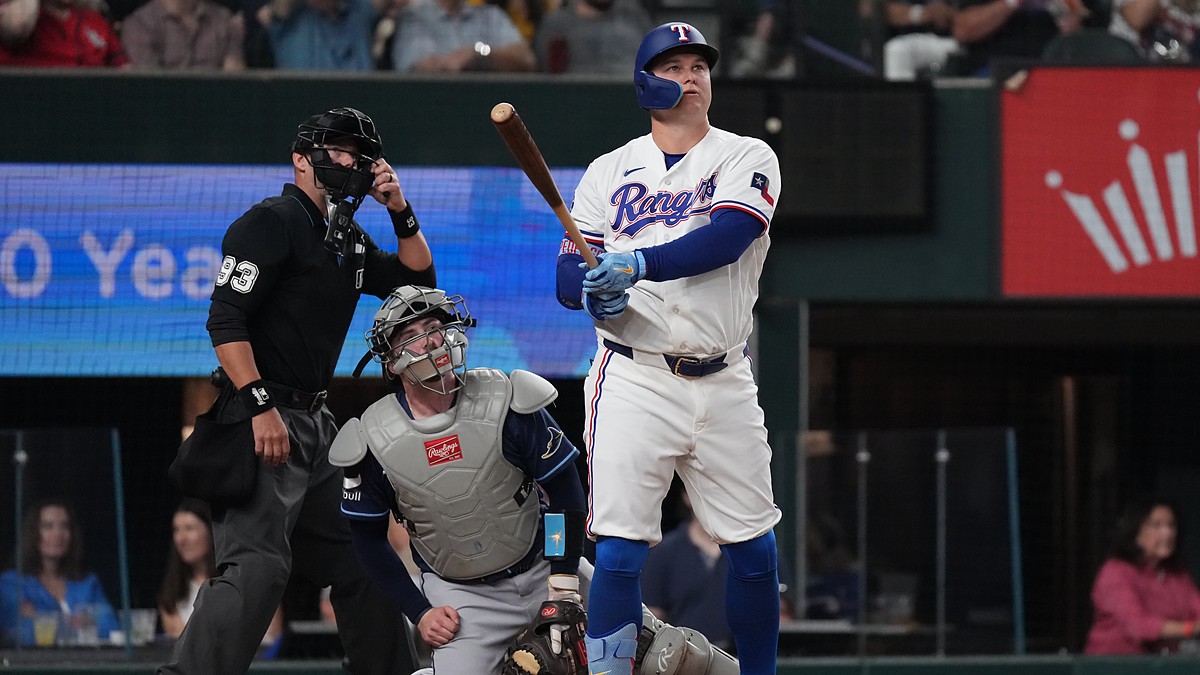 Texas Rangers first baseman Joc Pederson watches his home run as Tampa Bay Rays catcher Liam Hicks and the umpire look up.