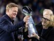 NFL commissioner Roger Goodell hands the Vince Lombardi Trophy to Seattle Seahawks chairman Jody Allen on the podium.