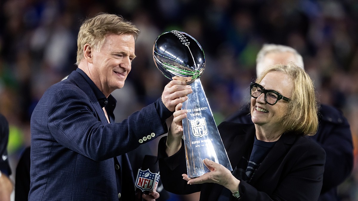 NFL commissioner Roger Goodell hands the Vince Lombardi Trophy to Seattle Seahawks chairman Jody Allen on the podium.