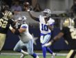 Dallas Cowboys quarterback Joe Milton III releases a pass as a Saints lineman raises an arm in front of him.