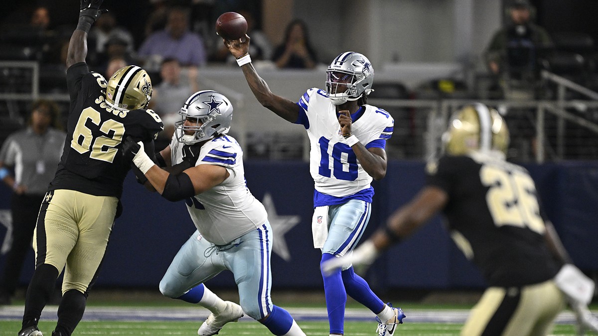 Dallas Cowboys quarterback Joe Milton III releases a pass as a Saints lineman raises an arm in front of him.