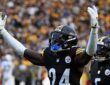 Pittsburgh Steelers cornerback Joey Porter Jr. raises both arms in celebration as teammates react behind him.