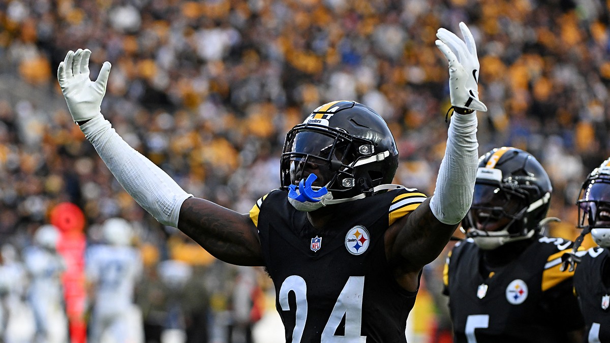 Pittsburgh Steelers cornerback Joey Porter Jr. raises both arms in celebration as teammates react behind him.