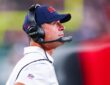 New York Giants head coach John Harbaugh looks up from the sideline wearing a headset during a game against the Jets.