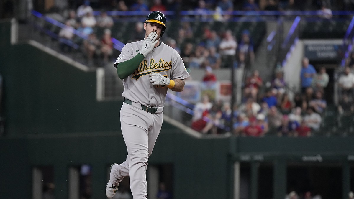 Athletics catcher Jonah Heim raises a hand toward the stands while rounding the bases after a home run.