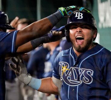 Tampa Bay Rays first baseman Jonathan Aranda shouts in the dugout as a teammate reaches for his helmet.