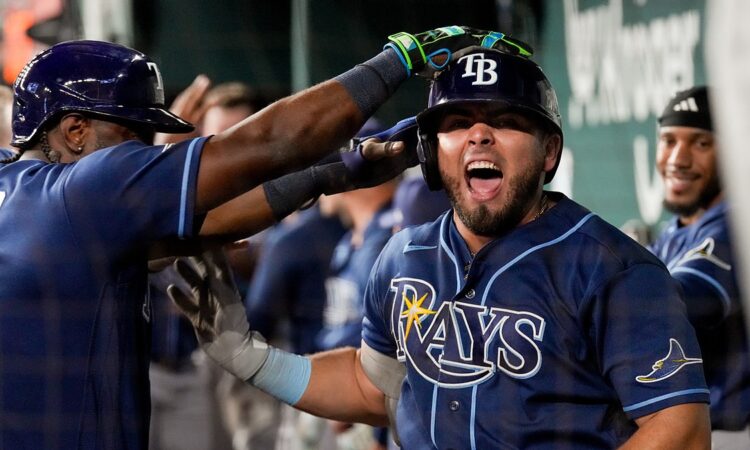 Tampa Bay Rays first baseman Jonathan Aranda shouts in the dugout as a teammate reaches for his helmet.