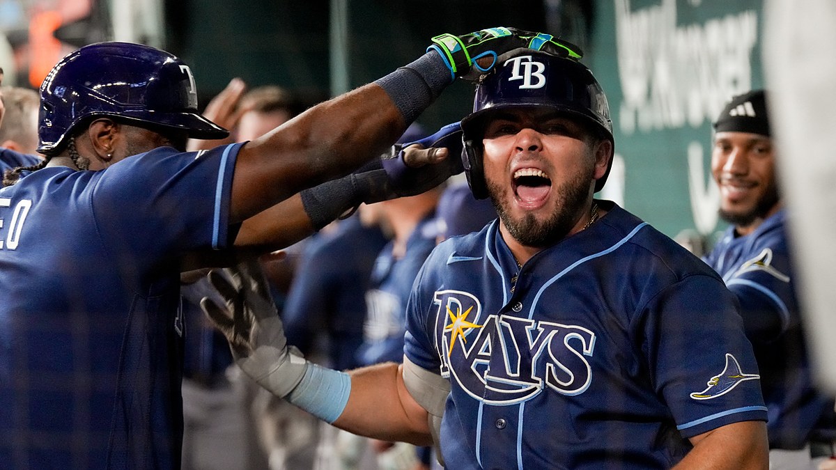 Tampa Bay Rays first baseman Jonathan Aranda shouts in the dugout as a teammate reaches for his helmet.