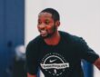 Minnesota Timberwolves forward Jonathan Kuminga smiles during a workout in a black Timberwolves T-shirt.