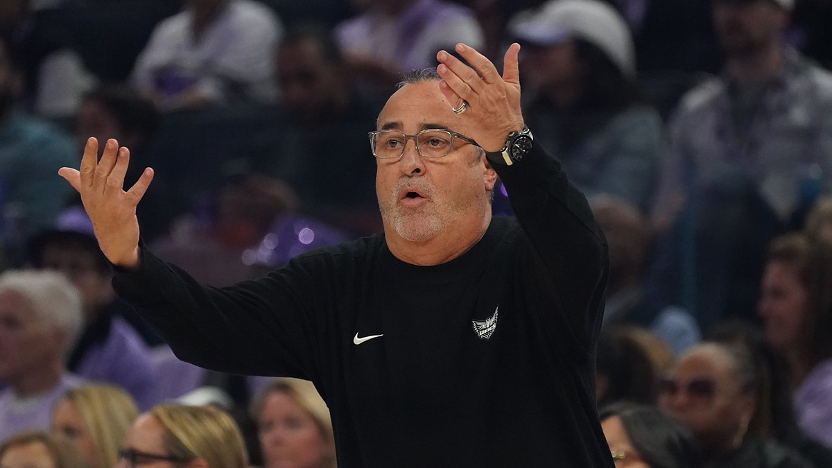 Dallas Wings head coach Jose Fernandez raises both hands as he reacts from the sideline.