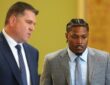 Green Bay Packers running back Josh Jacobs walks through a courtroom alongside his attorney.