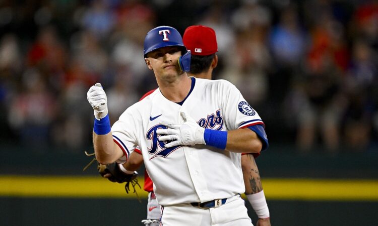 Texas Rangers third baseman Josh Jung pumps a fist at second base after hitting a double against the Angels.