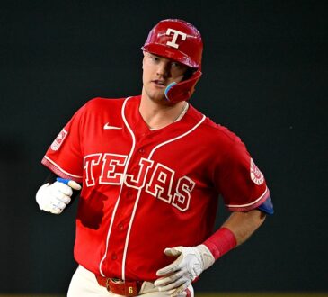 Texas Rangers third baseman Josh Jung jogs the bases in his red Tejas jersey after hitting a home run.