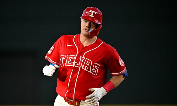 Texas Rangers third baseman Josh Jung jogs the bases in his red Tejas jersey after hitting a home run.