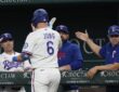 Texas Rangers third baseman Josh Jung high-fives manager Jared Schumaker and coaches at the dugout rail.