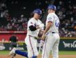 Texas Rangers third baseman Josh Jung fist bumps third base coach Corey Ragsdale while rounding the bases.