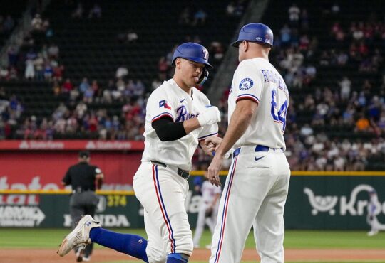 Texas Rangers third baseman Josh Jung fist bumps third base coach Corey Ragsdale while rounding the bases.
