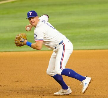 Rangers third baseman Josh Jung sets to throw to first base with the ball in his right hand.