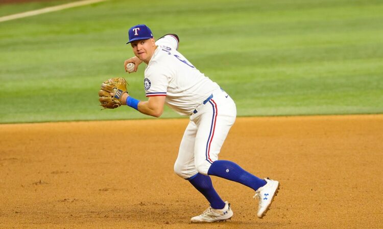 Rangers third baseman Josh Jung sets to throw to first base with the ball in his right hand.