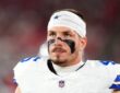Dallas Cowboys linebacker Justin Barron, wearing eye black and a Cowboys headband, looks up during a game.