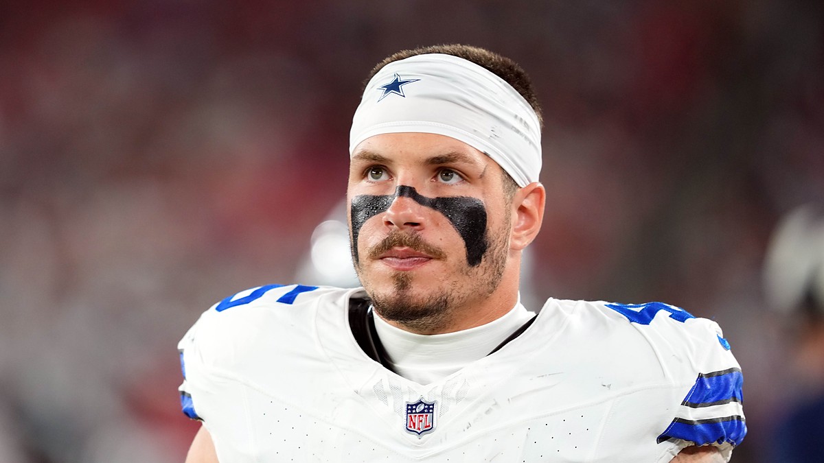 Dallas Cowboys linebacker Justin Barron, wearing eye black and a Cowboys headband, looks up during a game.