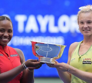 Taylor Townsend, left, and Kateřina Siniaková smile as they hold the U.S. Open women’s doubles trophy between them.