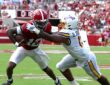 Alabama Crimson Tide quarterback Keelon Russell, No. 12, is grabbed by East Carolina linebacker DJ Johnson Jr. while running with the ball.