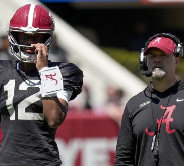 Alabama quarterback Keelon Russell stands beside offensive coordinator Ryan Grubb, who wears a headset, during a spring practice.