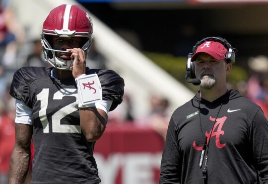 Alabama quarterback Keelon Russell stands beside offensive coordinator Ryan Grubb, who wears a headset, during a spring practice.