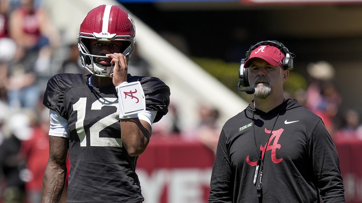 Alabama quarterback Keelon Russell stands beside offensive coordinator Ryan Grubb, who wears a headset, during a spring practice.