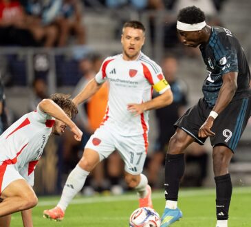 Minnesota United forward Kelvin Yeboah strikes the ball as FC Dallas midfielder Ran Binyamin slides in to block.
