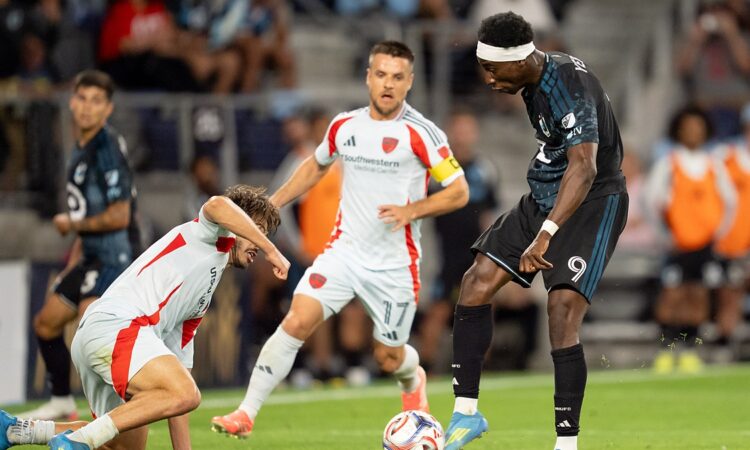 Minnesota United forward Kelvin Yeboah strikes the ball as FC Dallas midfielder Ran Binyamin slides in to block.
