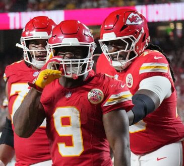 Kansas City Chiefs running back Kenneth Walker III gestures toward the camera as teammates join him after a touchdown.