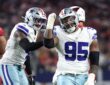 Dallas Cowboys defensive tackle Kenny Clark raises a fist beside defensive end Donovan Ezeiruaku after a sack.