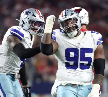 Dallas Cowboys defensive tackle Kenny Clark raises a fist beside defensive end Donovan Ezeiruaku after a sack.
