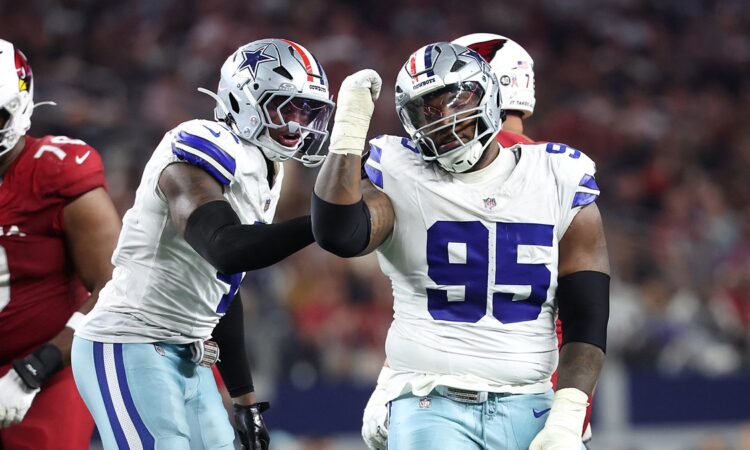 Dallas Cowboys defensive tackle Kenny Clark raises a fist beside defensive end Donovan Ezeiruaku after a sack.