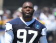Dallas Cowboys defensive tackle Kenny Clark stands on the practice field in a No. 97 jersey at training camp.