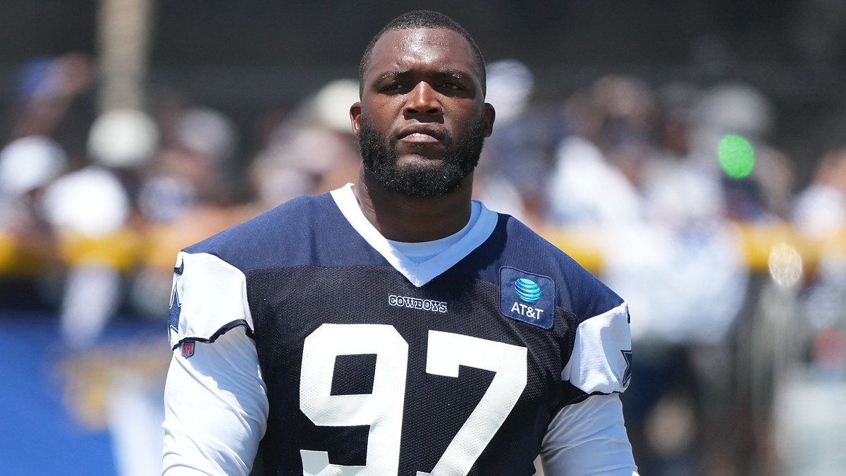 Dallas Cowboys defensive tackle Kenny Clark stands on the practice field in a No. 97 jersey at training camp.