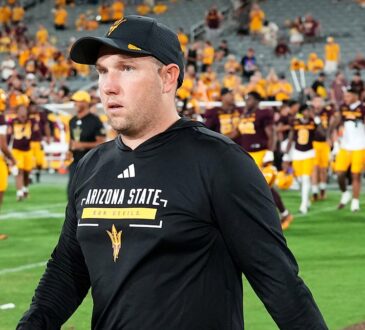 Arizona State Sun Devils head coach Kenny Dillingham walks across the field as his players gather behind him.