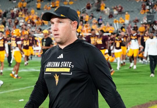 Arizona State Sun Devils head coach Kenny Dillingham walks across the field as his players gather behind him.
