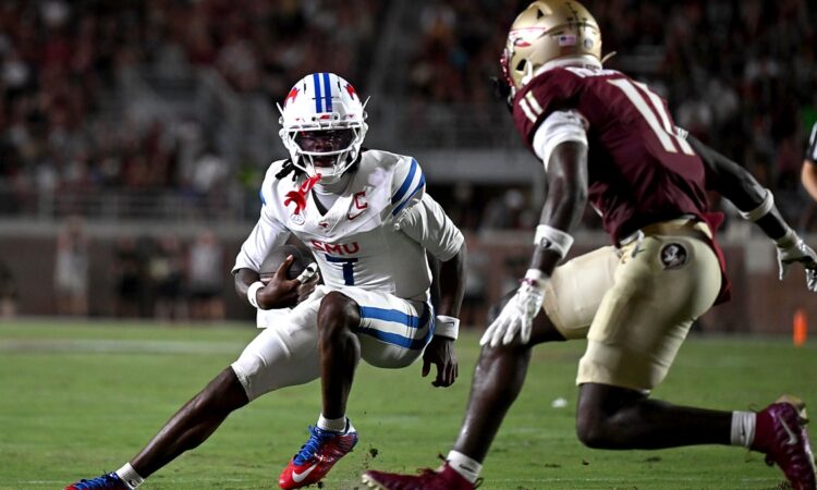 SMU Mustangs quarterback Kevin Jennings tucks the ball and cuts back as a Florida State defender closes in.