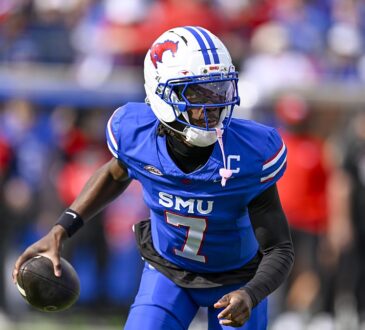 SMU Mustangs quarterback Kevin Jennings, No. 7, carries the ball in his right hand while running.