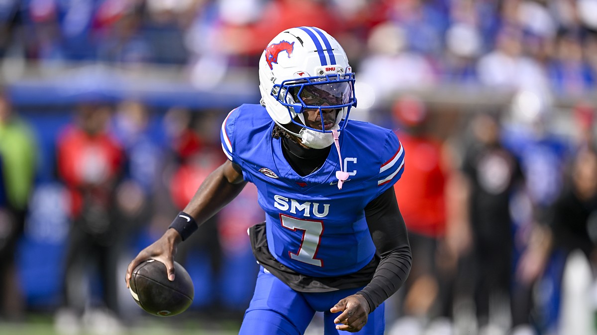 SMU Mustangs quarterback Kevin Jennings, No. 7, carries the ball in his right hand while running.