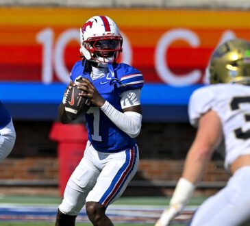 SMU quarterback Kevin Jennings drops back to pass with the ball at his chest as a UC Davis defender closes in.