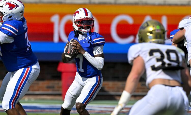 SMU quarterback Kevin Jennings drops back to pass with the ball at his chest as a UC Davis defender closes in.