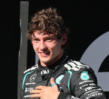 Mercedes driver Andrea Kimi Antonelli smiles with his hand on his chest while wearing his race suit.